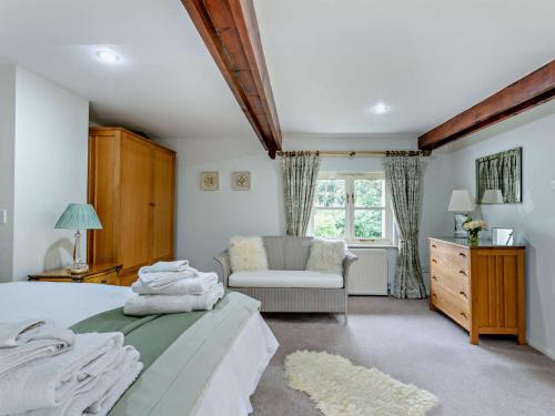 Sampford Courtenay4 bed in Okehampton 49511的卧室配有床、椅子和窗户。