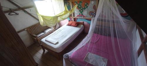 莫姆皮切Hostal Camping Sin Fronteras Mompiche的小房间设有床和窗户