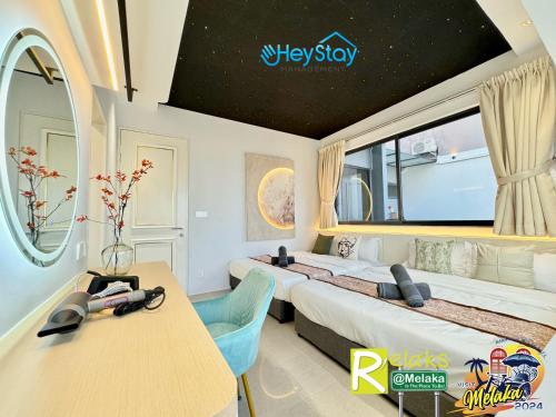 马六甲Imperio Residence By Heystay Management的一间卧室设有两张床、一张桌子和一个窗口