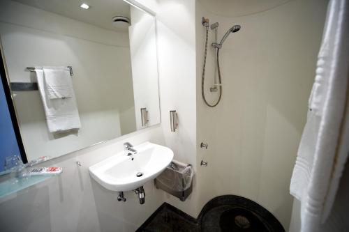 Brøndbyvester埃德瑞特斯酒店的白色的浴室设有水槽和淋浴。