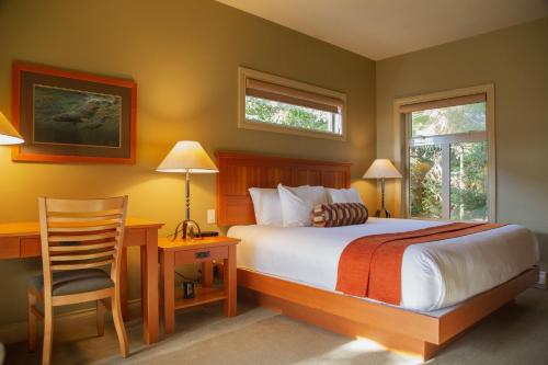 托菲诺长滩度假旅舍的一间卧室配有一张床、一张桌子和一把椅子