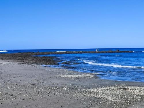 VenadoCasa Lagarto Beachfront的一片蓝水海滩和岩石海岸线