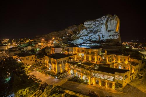 于尔居普卡帕多西亚弗雷斯科窟套房酒店的夜晚的城市景观与岩石