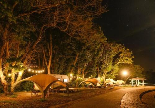 KakajiNagasaki Hana Beach Resort - Vacation STAY 26612v的一群晚上在公园里的帐篷