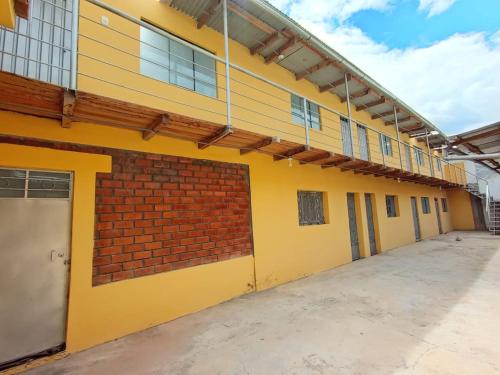 瓦努科OCALA HOUSE 4.0的一座空的学校建筑,上面有黄色的油漆和砖墙