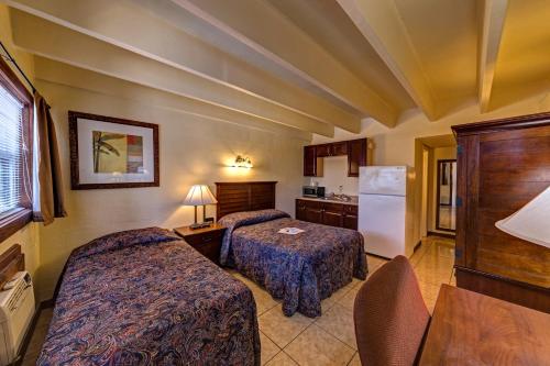 Merritt IslandAladdin Motel By OYO Merritt Island的酒店客房配有两张床和一台冰箱