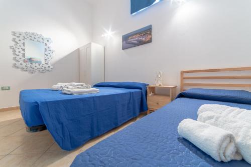 阿夸里卡德尔卡波Casa Vacanza Pamela的配有两张床铺的客房提供蓝色的床单和毛巾