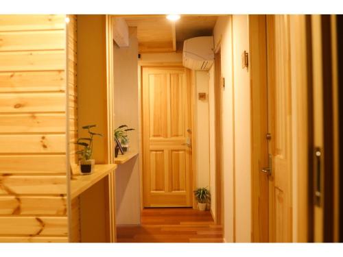 美瑛町Phottage inn Biei - Vacation STAY 20949v的走廊上有一扇门,里面有些植物
