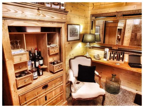 希伯维列La Grange du couvent B&B的配有椅子和书桌及葡萄酒瓶的房间