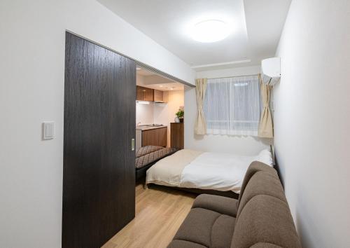 东京Repure Omori Residence - Vacation STAY 16383的一间卧室配有一张床和一个沙发