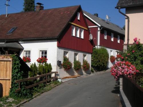 PresseckFerienhaus "Lena"的街道边的红白色房子,花朵花