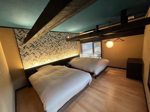 SudagaiTonegun - House - Vacation STAY 16434的一间卧室设有两张床和一堵墙