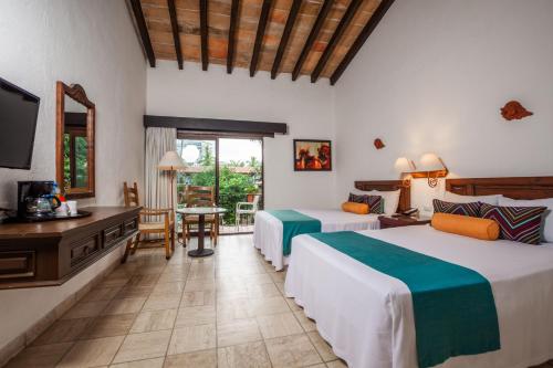 巴亚尔塔港布埃纳文图拉庄园墨西哥魅力酒店 - 全包 的酒店客房设有两张床和电视。