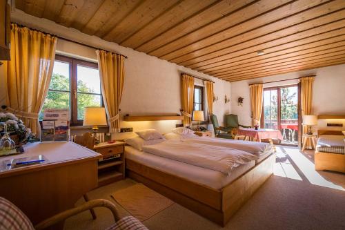 巴特莱辛哈尔Landhotel Sonnleiten的一间卧室配有一张大床和一张书桌