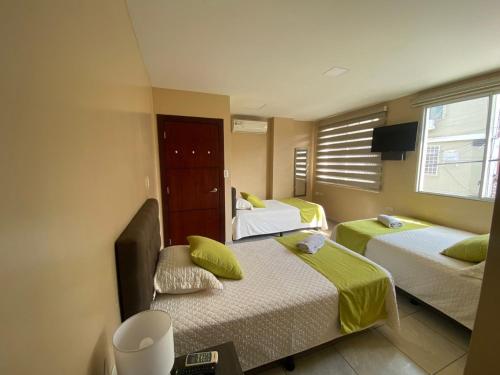 曼塔YORMARI HOTEL的酒店客房设有两张床和窗户。