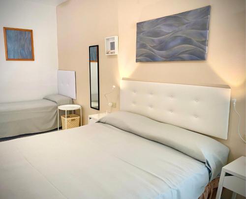 CavoliHotel Lorenza B&B e Mini Suite的卧室配有白色的床和墙上的绘画作品