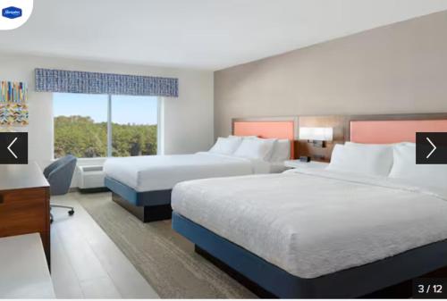 Hampton Inn & Suites Fultondale的酒店客房设有两张床和窗户。