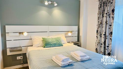 BiscoitosCasa da Gente的一间卧室配有一张床,上面有两条毛巾