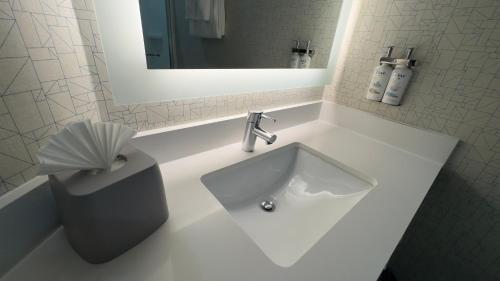 滨海城马里那智选假日套房酒店的浴室设有白色水槽和镜子