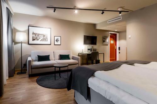 斯德哥尔摩斯堪迪克公园酒店的一间卧室配有一张床、一张沙发和一张桌子