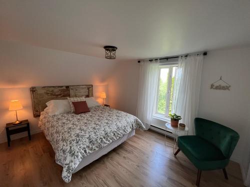三河城Gite - La ruée vers l'orge的一间卧室配有一张床和一把绿色椅子