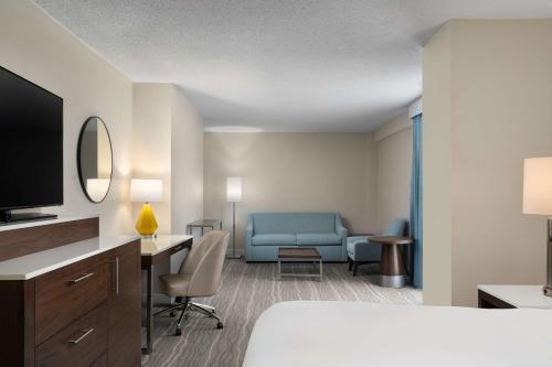 诺福克诺福克机场希尔顿逸林酒店的配有一张床和一张书桌的酒店客房