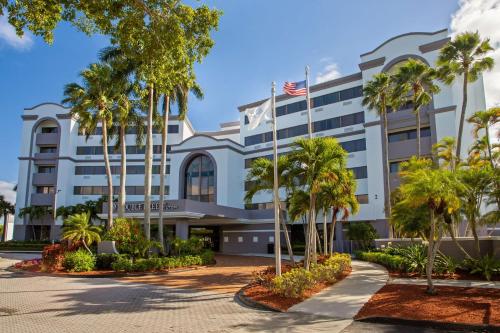 西棕榈滩DoubleTree by Hilton Hotel West Palm Beach Airport的前面有棕榈树的酒店