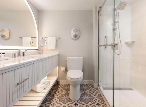 棕榈滩海岸The Singer Oceanfront Resort, Curio Collection by Hilton的白色的浴室设有卫生间和淋浴。