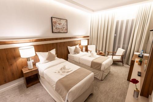 麦加Wassad Hotel Makkah فندق وسد مكة的酒店客房,配有两张床和椅子