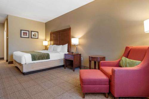 Amite阿米特康福特茵酒店的配有一张床和一把椅子的酒店客房