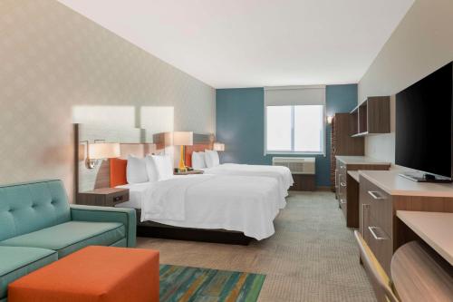 雷德兰兹Home2 Suites By Hilton Redlands的酒店客房,配有床和电视