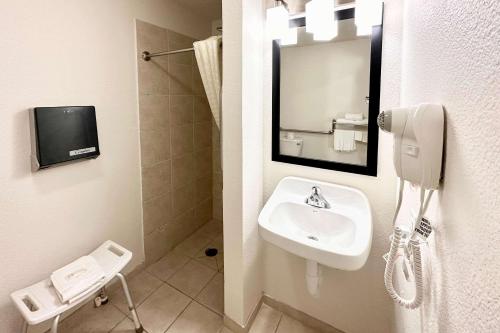 麦迪逊MainStay Suites Madison Airport的一间带水槽的浴室和墙上的一部电话