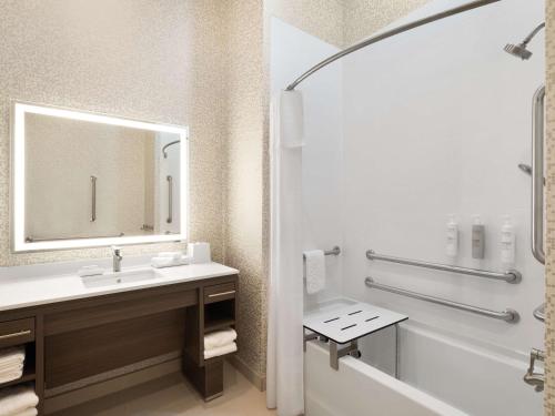 圆石城Home2 Suites By Hilton Round Rock Medical Center的一间带水槽、浴缸和镜子的浴室
