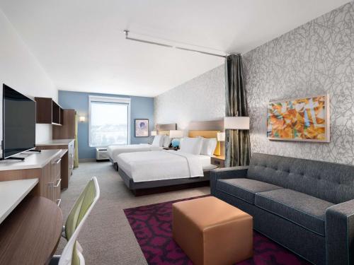 圆石城Home2 Suites By Hilton Round Rock Medical Center的酒店客房,配有床和沙发
