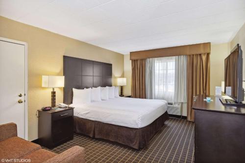 摩根敦Quality Inn & Suites Morgantown - University Area的配有一张床和一张书桌的酒店客房