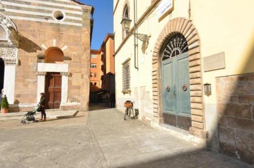 卢卡Ferienwohnung für 4 Personen ca 75 qm in Lucca, Toskana Provinz Lucca的一座建筑,旁边设有一扇蓝色的门和一辆自行车
