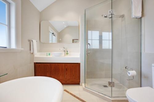 奥克兰Grande Vista 5Br Manor with Pool & Mt Eden Views的带淋浴和盥洗盆的浴室