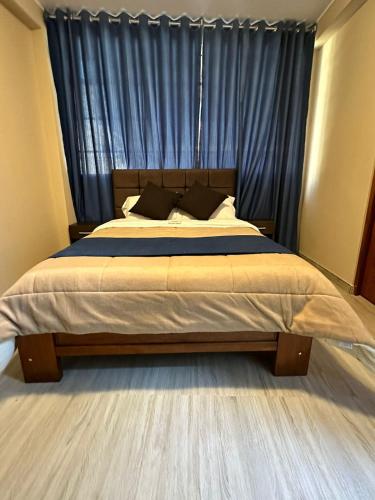 YungayGran Hotel的一间卧室配有一张带蓝色窗帘的大床