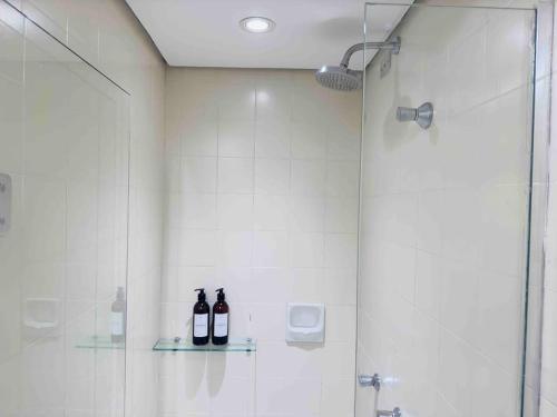 库里提巴A melhor opção no centro com vista panorâmica的浴室玻璃架上的两瓶葡萄酒
