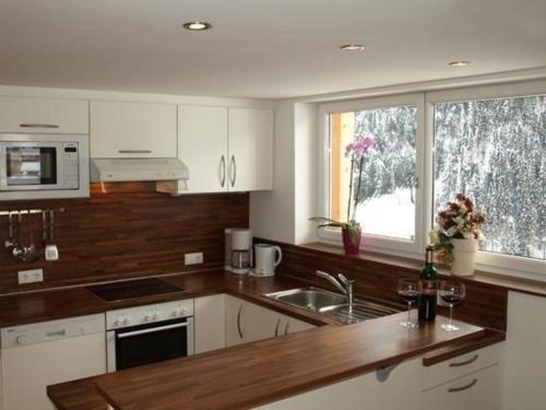 卡普尔Appartement in Kappl mit Eigenem Balkon的厨房配有白色橱柜、水槽和窗户。