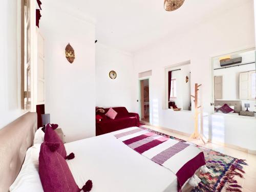 马拉喀什Riad Des Sables的卧室配有白色的床和红色沙发
