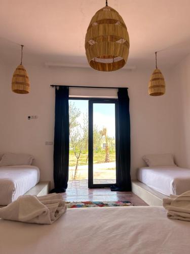 马拉喀什Aghmat Lodge Guest house的客房设有两张床和窗户。