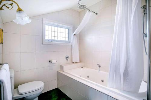 莫宁顿Mornington Guest House的白色的浴室设有浴缸和卫生间。