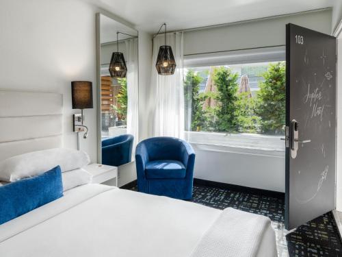 波特兰朱庇特酒店的卧室配有床、椅子和窗户。