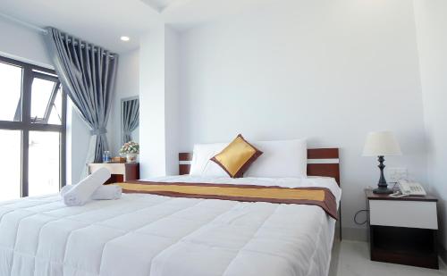 归仁Tân Thi Hotel的卧室配有一张大白色床和窗户