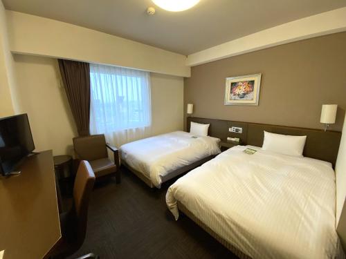花卷市花卷市鲁特酒店的酒店客房设有两张床和电视。