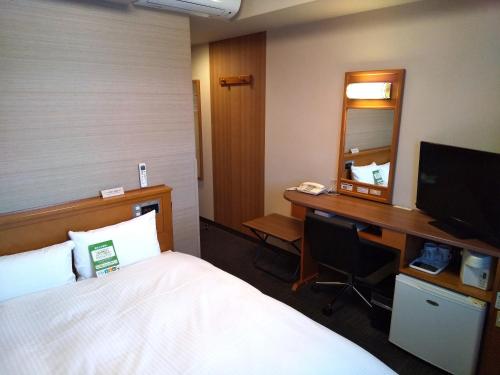 大馆市Hotel Route-Inn Odate Omachi的酒店客房配有一张床和一张带镜子的书桌
