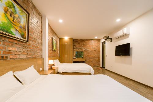 宁平King Kong Homestay的一间卧室设有两张床和砖墙