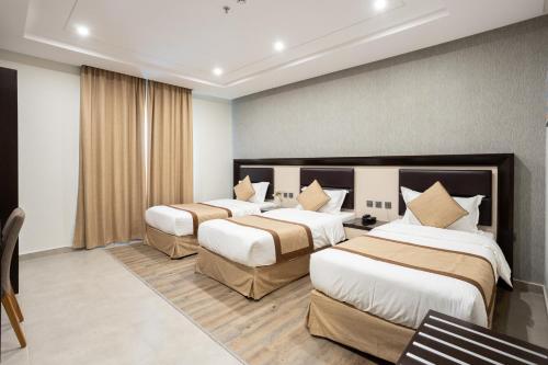 麦地那سدو بوتيك للشقق الفندقية - SDU Boutique Hotel Apartments的一间酒店客房,房间内设有三张床