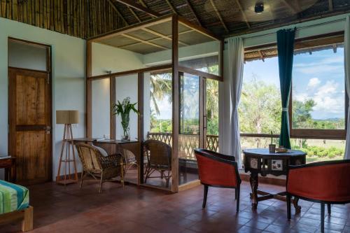 蒂鲁瓦纳马莱Gia Mantra Eco Resort/stay的客房设有带椅子和桌子的阳台。
